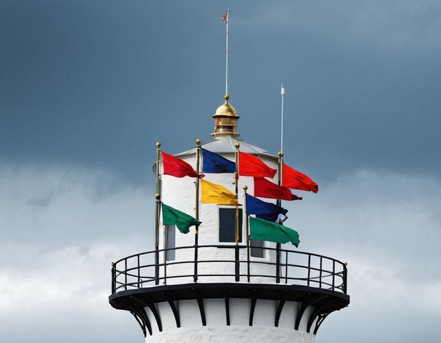 Des pavillons de signaux au mât, en haut du phare